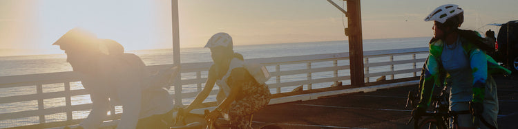 A group of cyclists riding together during sunset
