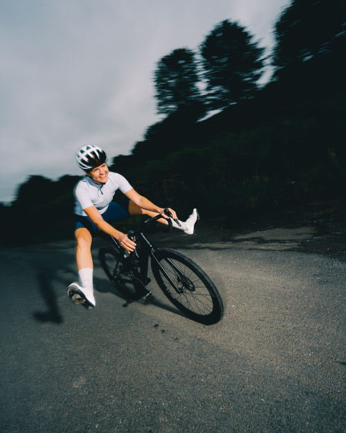 Cyclist riding on a road with trees in the background